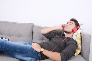 Man listening music on couch.