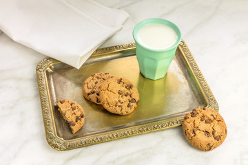 Chocolate chips cookies and milk on vintage tray