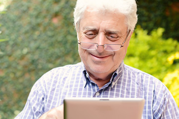 Old man using digital tablet.