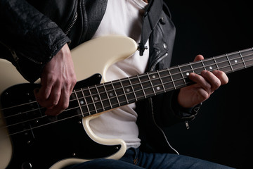 Obraz na płótnie Canvas Rockstar in biker leather jacket playing solo on bass guitar.