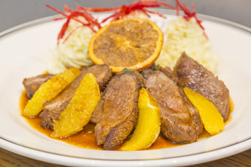 Roasted duck with mash potato and lemon.