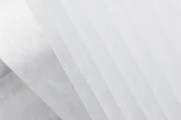 background of translucent white porous textile with straight lines. background of translucent fabric of smoky shade