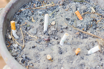 Smoked Cigarettes Butts in a Public Ashtray, selective focus