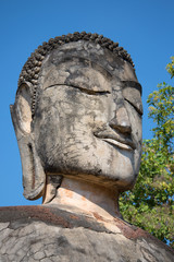The head of an ancient Buddha statue closeup. The ruins of the ancient Buddhist temple Wat Phra Kaeo. Kamphaeng Phet, Thailand
