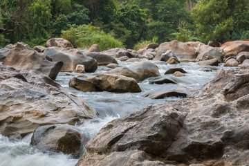 Naklejka na ściany i meble Beautiful River water flowing through stones and rocks at dawn