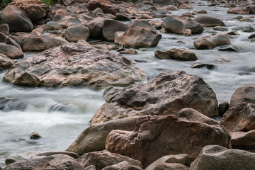 Beautiful River water flowing through stones and rocks at dawn