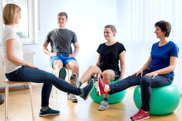 Sportgymnastik in der Gruppe auf Gymnastikbällen in der Physiotherapie Praxis
