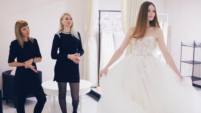 Young woman chooses a wedding dress in bridal shop