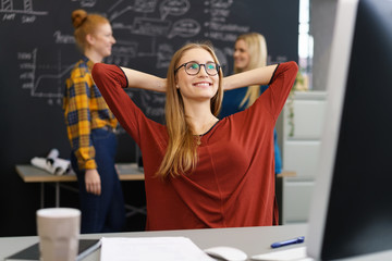 frau im büro schaut zufrieden nach oben