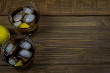Cold Cola with ice and lemon in glasses