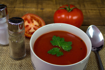 Soup tomato in white bowl with parsley and tomatoes
