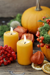 Fototapeta na wymiar Two orange candles among other autumn decorations.