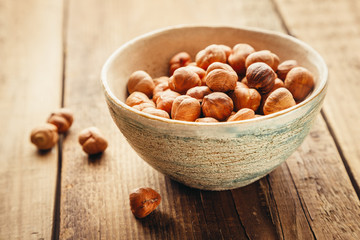 hazelnuts iHazelnuts in a bowl on a old rustic table. Shallow DOFn a bowl