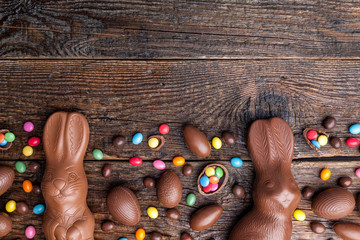 Chocolate Easter bunny and eggs on wooden background