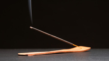 Incense stick smokes on a table