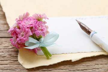 Beautiful tiny bouquet of pink kalanchoe blossfeldiana flowers and vintage letters, copy space