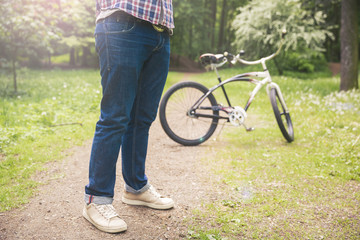 Man standing on path at park with bicycle