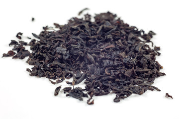 Dry black tea leaves isolated on white background