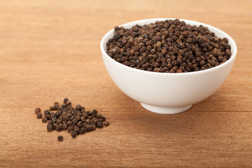 black peppercorns in white ceramic bowl