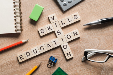 Conceptual keywords on wooden table with elements of game making crossword