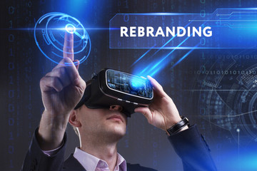 Business, Technology, Internet and network concept. Young businessman working in virtual reality glasses sees the inscription: Rebranding