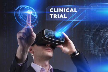Business, Technology, Internet and network concept. Young businessman working in virtual reality glasses sees the inscription: Clinical trial
