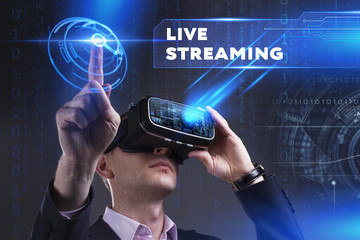 Business, Technology, Internet and network concept. Young businessman working in virtual reality glasses sees the inscription: Live streaming