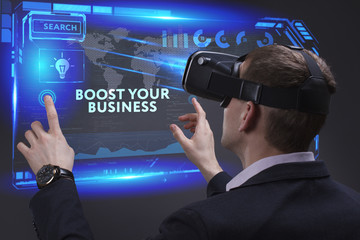 Business, Technology, Internet and network concept. Young businessman working on a virtual screen of the future and sees the inscription: Boost your business