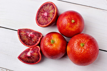 Several blood oranges ,whole and halved on a wooden table.top view