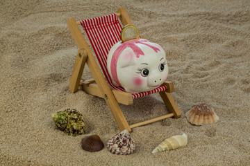 Liegestuhl mit Sparschwein und Euro