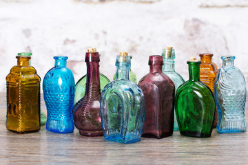 Coloured glass bottles on a rustic background