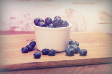 Pot of blueberries on a rustic background