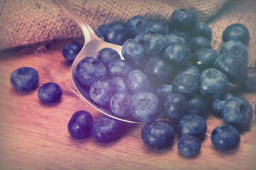 Blueberries and spoon on a rustic background