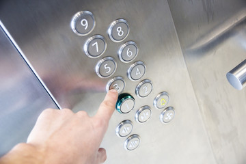 finger points to third floor of modern elevator