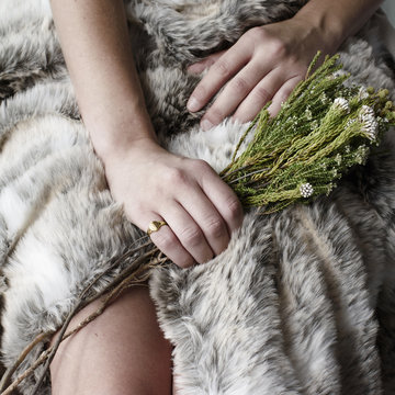 Young woman hand holding bunch of flowers