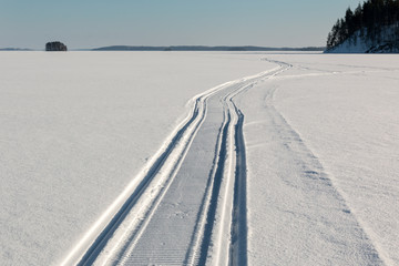 Snowmobile trail on frozen lake