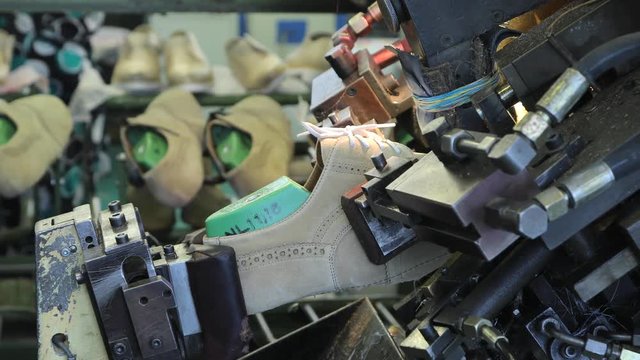 Machine for shaping shoes. Manufacturing shoes in a shoe factory.