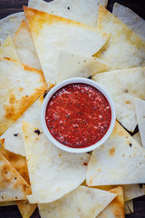 Hot salsa dip over the hip of nachos chips - organic home made sauce.