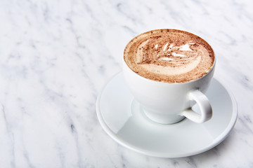 Cup of cappuccino on the table, coffee shop background