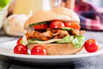 Fried chicken meat with cheese and vegetables in bun
