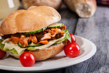 Fried chicken meat with cheese and vegetables in bun