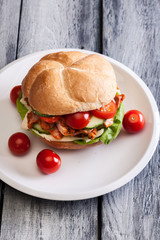 Fried chicken meat with cheese and vegetables in bun