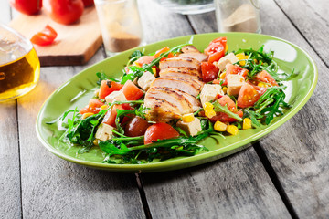 Fresh salad with chicken breast, arugula and tomato
