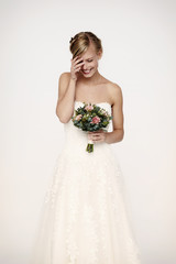 Laughing bride in white dress with flowers