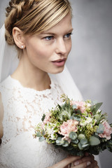 Blue eyed blond bride holding flowers