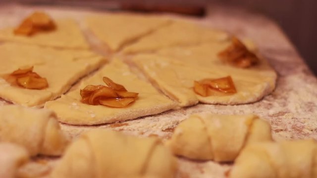 A woman puts on fresh pieces of dough apricot jam