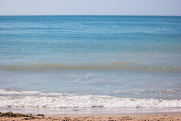 Foam on seashore. Blue sea and sky. Best spot for summer vacation. Sunbathe and swim.