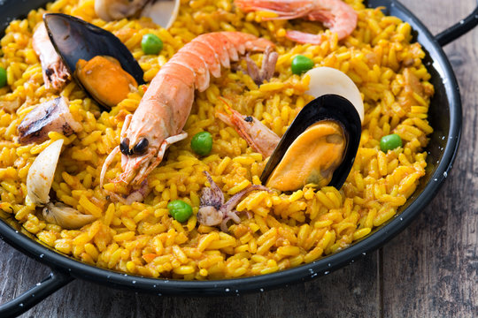 Traditional spanish seafood paella on wooden background.
