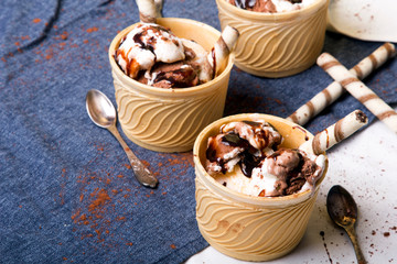 Delicious ice cream in a cup with chocolate sauce cream rolls