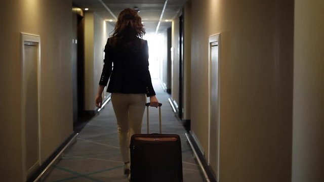 Familiar Passages of my Favorite Hotel. Businesswoman walks through the hotel corridor